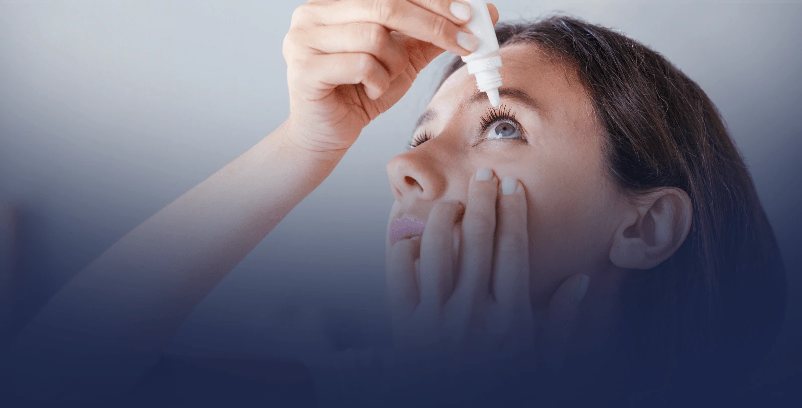 A woman putting eye drops into her eye