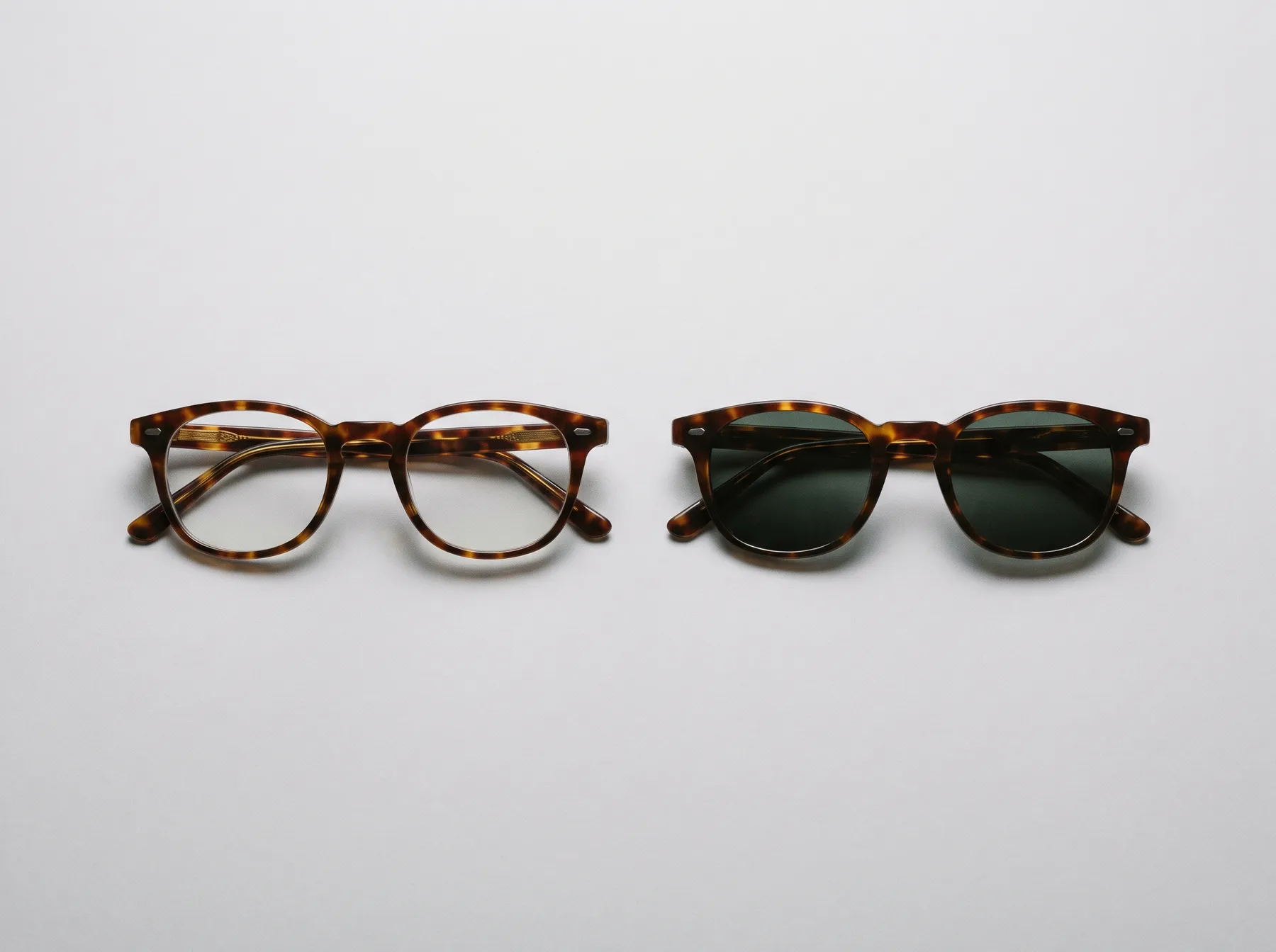 Prescription glasses beside a matching pair of prescription sunglasses