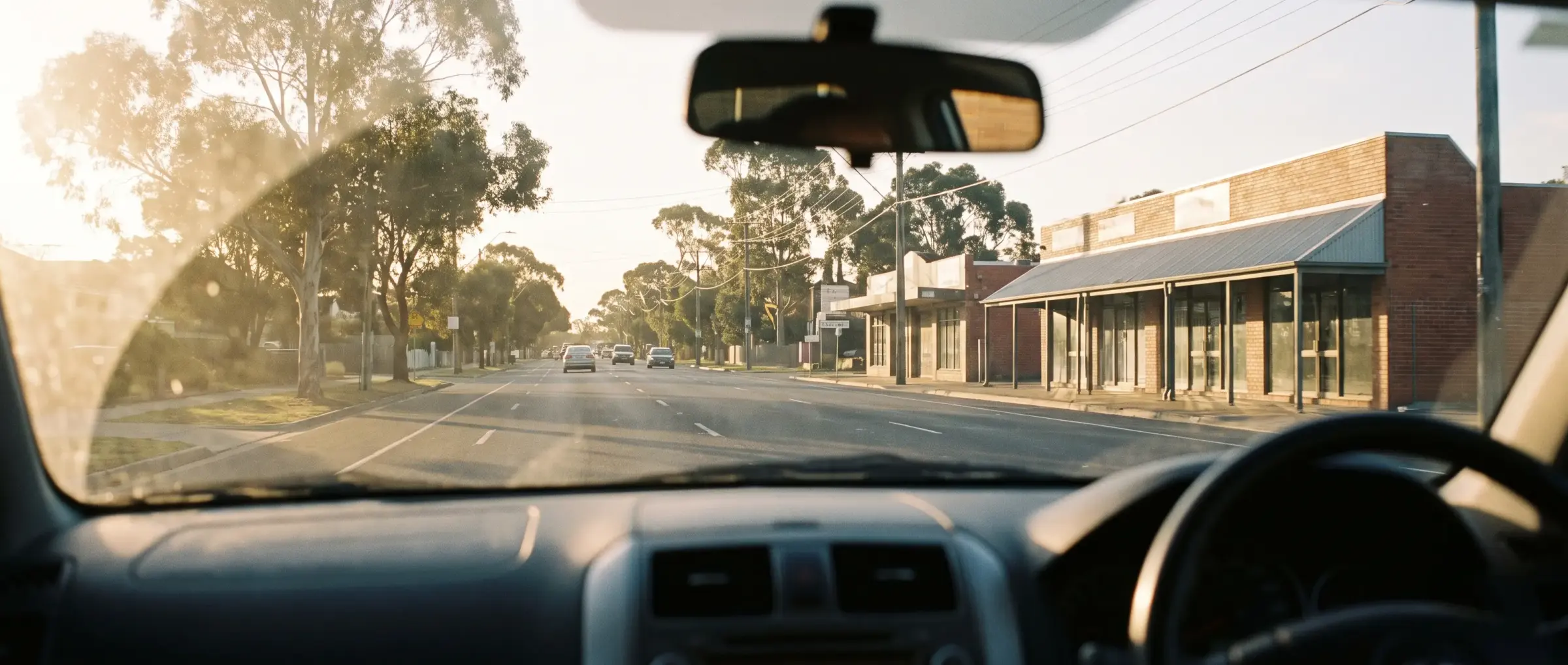 The view through a car windscreen on a suburban road